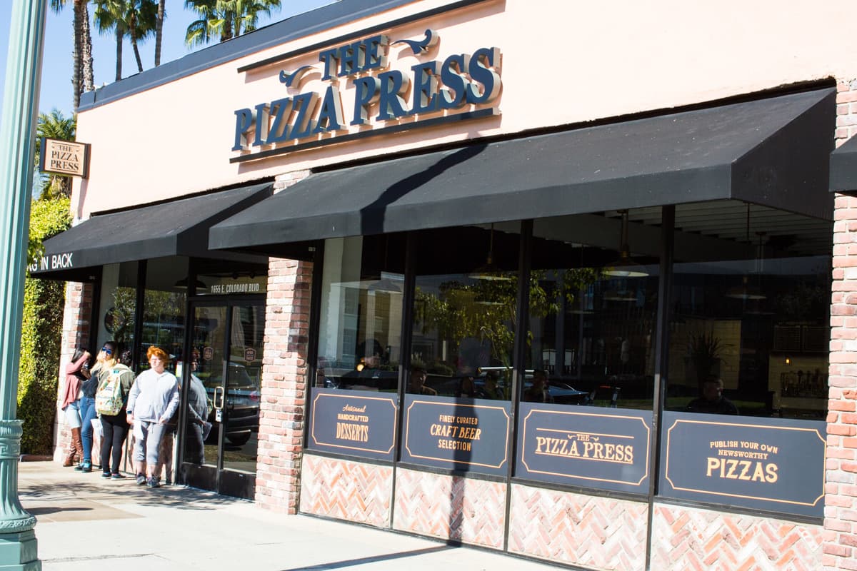 Pizza Press storefront with black awning and brick facade