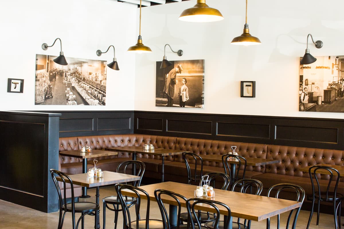 Leather banquette seating under pendant lights and framed photography